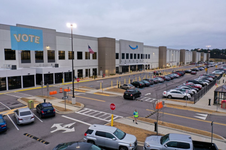 A banner with âVOTEâ on it is displayed facing the employee parking lot at an Amazon facility on the first day of the unionizing vote, in Bessemer, Alabama, U.S., February 4, 2022.