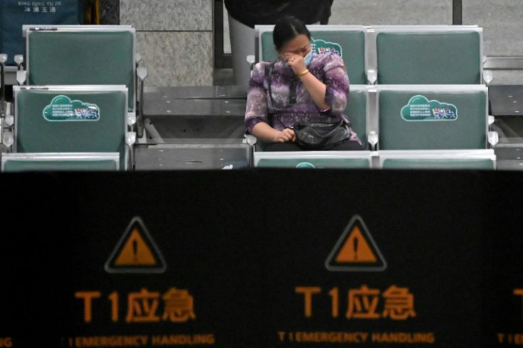 A relative of a passenger onboard China Eastern Flight MU5735, which crashed onto a mountainside in southern China, reacts while sitting at Guangzhou Baiyun International Airport, awaiting news