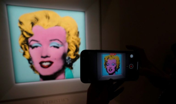 A journalist takes photos during a press preview March 21, 2022 in New York as Christie's announces "Shot Sage Blue Marilyn" by Andy Warhol will lead its Marquee Week of sales in May
