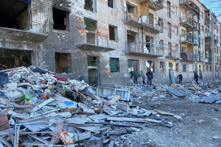 Municipal workers and volunteers remove debris of a damaged residential building, as Russia's attack on Ukraine continues, in Kharkiv, Ukraine March 21, 2022.