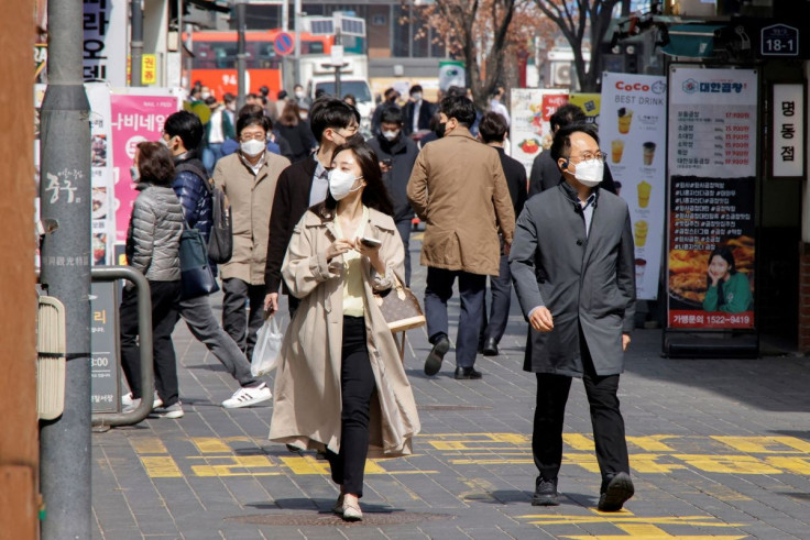 People wearing masks walk in a shopping district amid the coronavirus disease (COVID-19) pandemic in Seoul, South Korea, March 16, 2022.