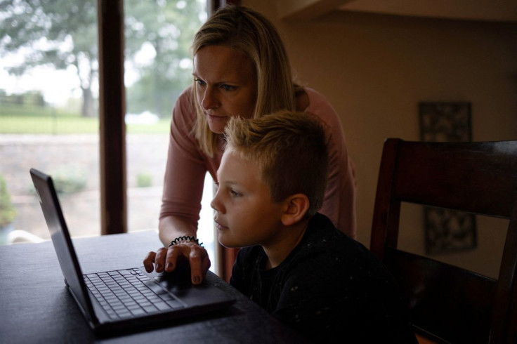 A mother helps her son with his homework at their home in  Pennsylvania, U.S., September 22, 2021. Picture taken September 22, 2021. 