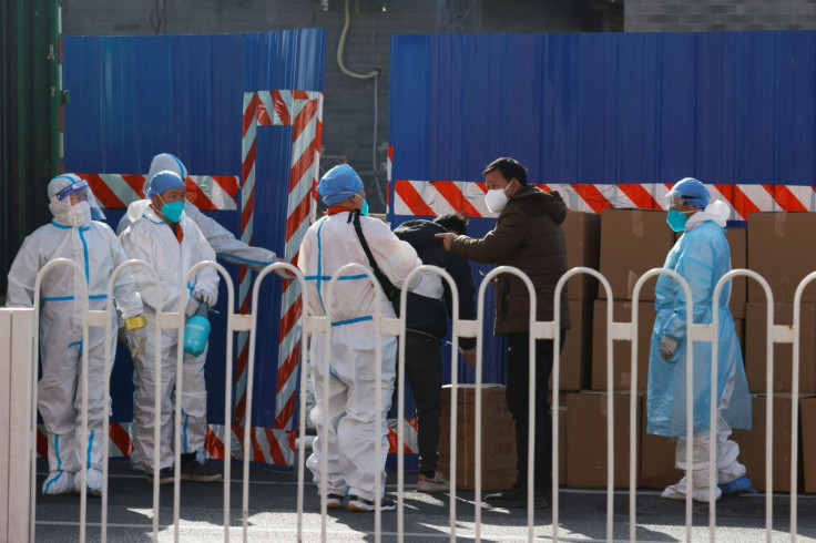 Workers in protective suits stand near boxes outside a sealed off area following the coronavirus disease (COVID-19) outbreak in Beijing, China March 21, 2022. 