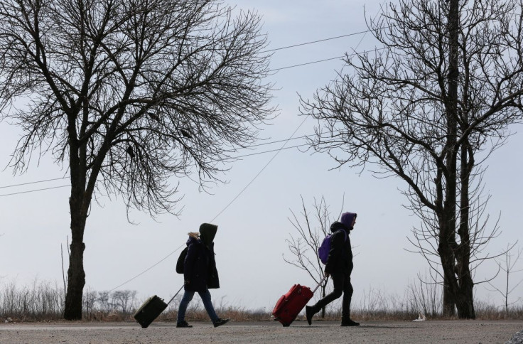 Refugees walk along a road as they leave the city during Ukraine-Russia conflict in the besieged southern port of Mariupol, Ukraine March 20, 2022. 