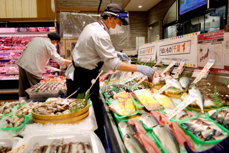 A worker wearing a face shield sells fish at a Japanese supermarket, Japan May 28, 2020. 