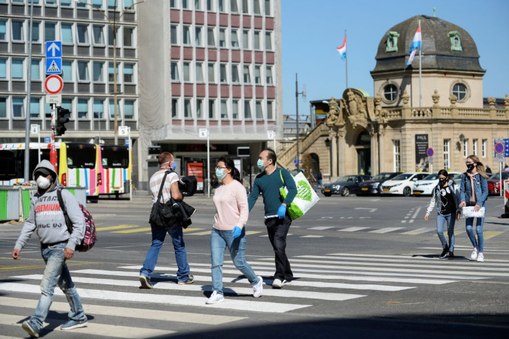 People wear protective masks as they cross the street during the coronavirus disease (COVID-19) outbreak in central station of Luxembourg, in Luxembourg, April 20, 2020. Reuters/ Johanna Geron