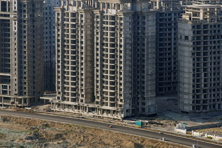 A vehicle travels past some of the 39 buildings developed by China Evergrande Group that authorities have issued demolition order on, on the man-made Ocean Flower Island in Danzhou, Hainan province, China January 6, 2022.