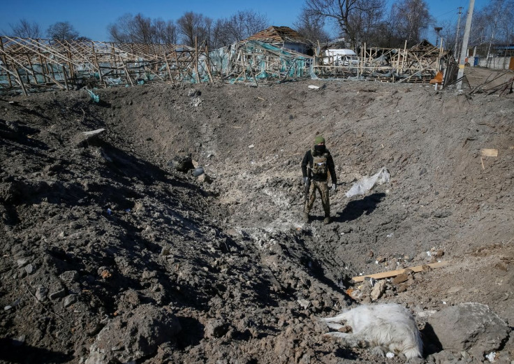 A Ukrainian service member inspects a shell crater, as the Russian invasion continues, in a village on the front line in the east Kyiv region, Ukraine March 21, 2022.