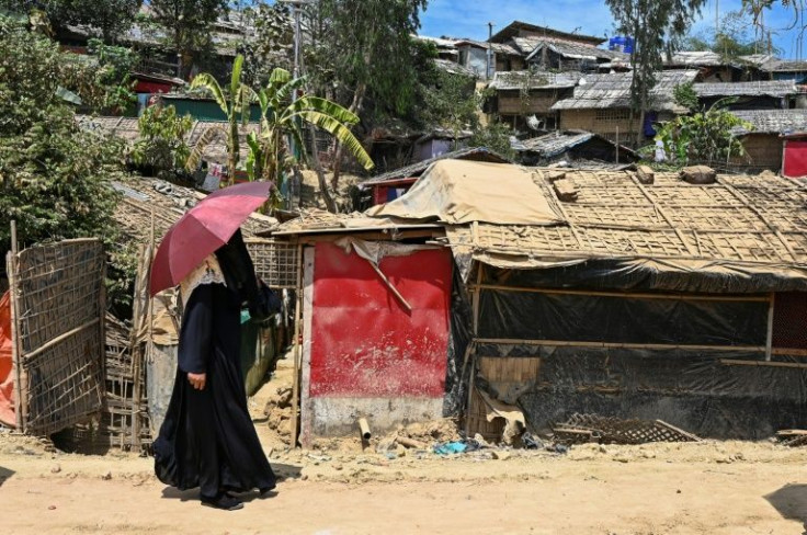 A Rohingya refugee woman walks along a road at Jamtoli refugee camp in Ukhia, Bangladesh