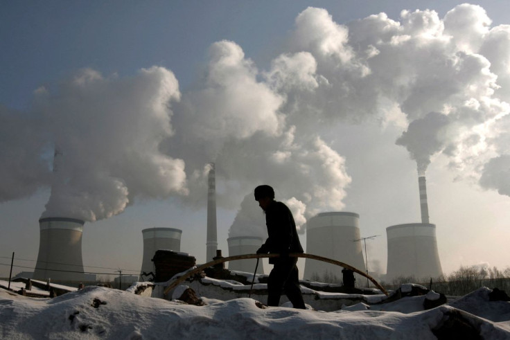 A villager walks in front of a coal-fired power plant on the outskirts of Datong, Shanxi province, November 20, 2009.