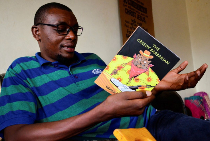Ugandan author of "Greedy Barbarian" Kakwenza Rukirabashaija reads the book at his home in Iganga district in Eastern Uganda May 11, 2020. Picture taken May 11, 2020.