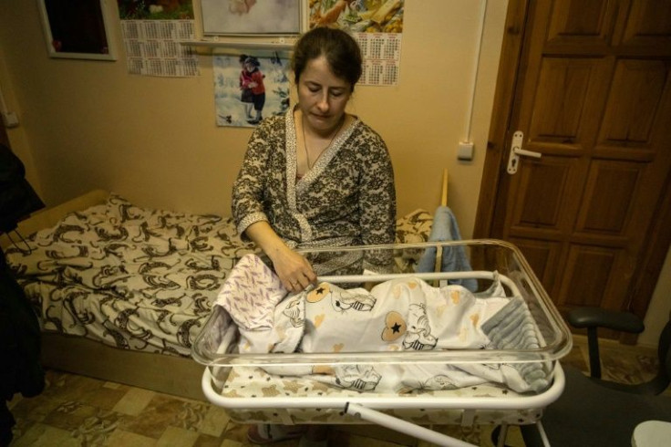 Mothers tend to their new-born babies in tiny rooms in a sweltering basement where they hide from bombs