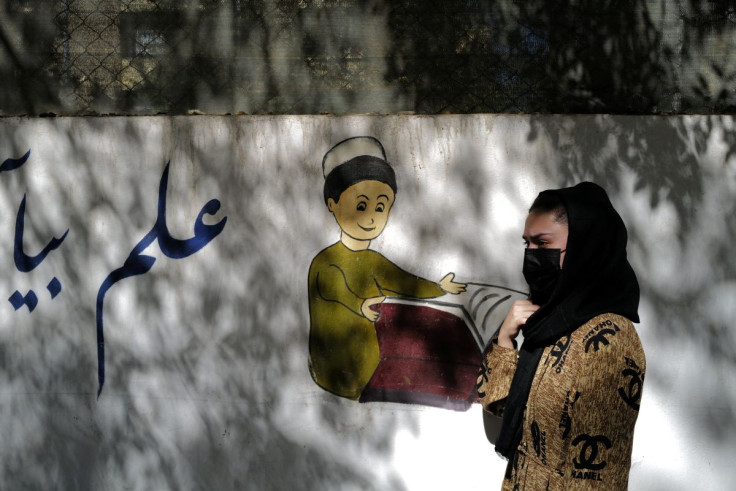FILE PHOTO - Sahar, 17, an 11th grade secondary school student, walks past her former school in Kabul, Afghanistan, October 20, 2021.