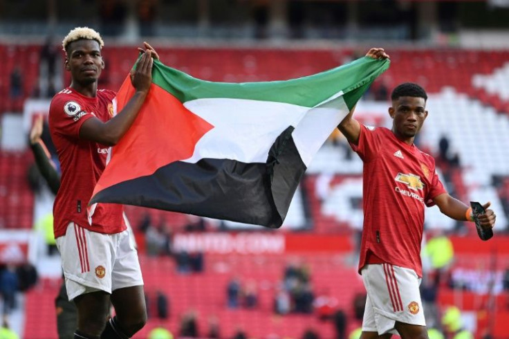 Manchester United midfielders Paul Pogba and Amad Diallo parade the Palestinian flag after a Premier League home tie against Fulham on May 18, 2021
