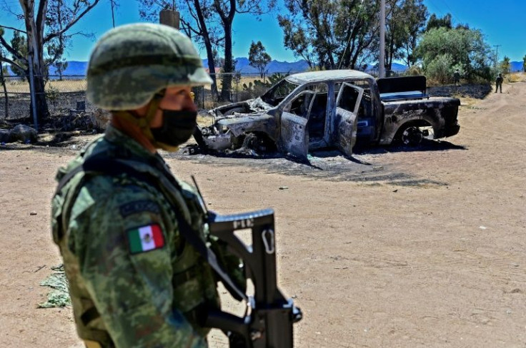 A Mexican soldier stands guard in the village of Palmas Altas, whose residents fled a turf war between rival gangs