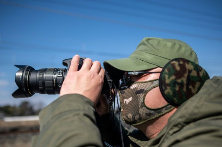 Train photography enthusiast Tsutomu Okawa reviews his latest image near a railway track in Hasuda, Saitama prefecture