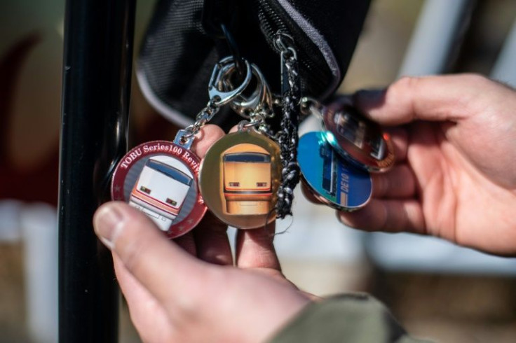 A "toritetsu" shows off his train-themed keychains during an interview with AFP