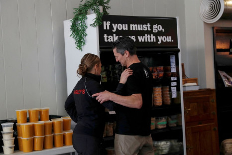 Amy and Chris Hillyard, owners of Farleyâs East cafe that closed due to the financial crisis caused by the coronavirus disease (COVID-19), embrace at the cafe in Oakland, California, U.S. March 18, 2020.