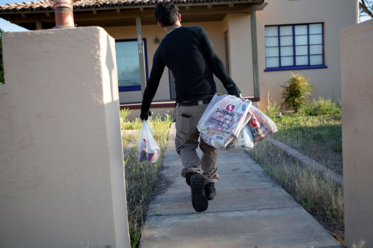 Instacart employee Eric Cohn, 34, delivers groceries to a residence while wearing a respirator mask to help protect himself and slow the spread of the coronavirus disease (COVID-19) in Tucson, Arizona, U.S., April 4, 2020. Picture taken April 4, 2020.