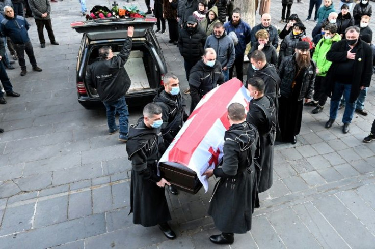 People attend a farewell ceremony for David Ratiani, a Georgian volunteer fighter killed during the ongoing Russian military action in Ukraine, at a church in Tbilisi on March 25, 2022
