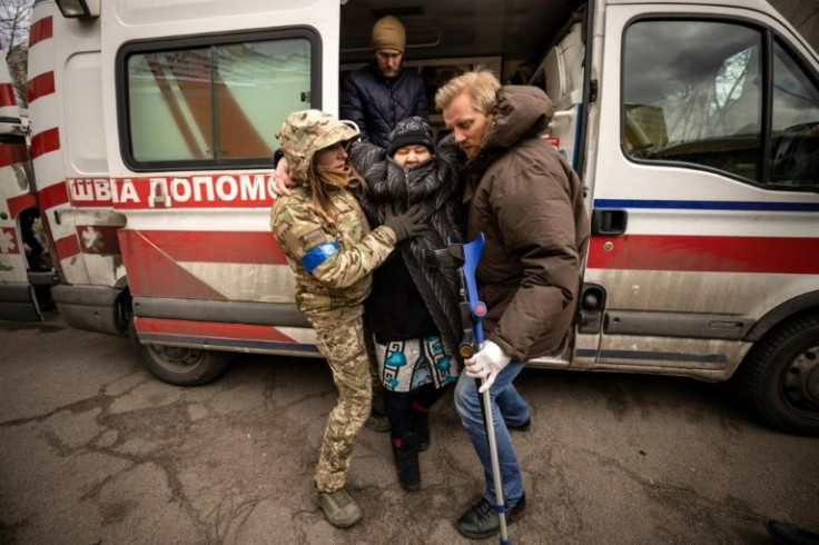 A woman is helped out of an ambulance after fleeing her home in the Kyiv suburb of Stoyanka on March 27, 2022