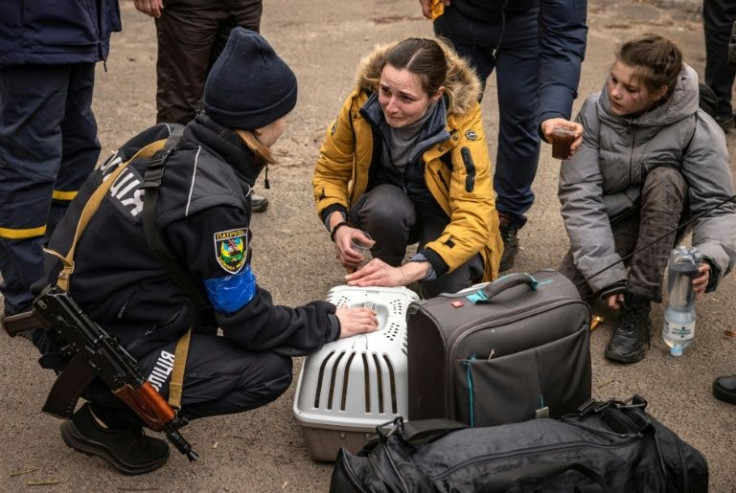 A woman reacts as she is assisted by police after fleeing a Kyiv suburb