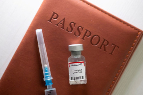 A syringe and a vial labelled "coronavirus disease (COVID-19) vaccine" are placed on a passport in this illustration taken April 27, 2021. 