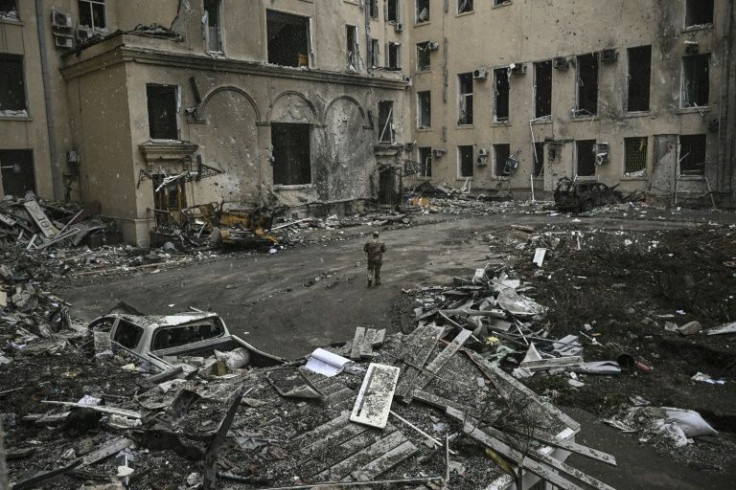 A Ukranian soldier walks among the rubble of the destroyed regional headquarters in Kharkiv