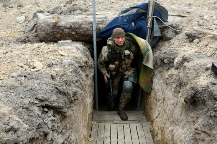 A Ukrainian serviceman walks along a trench on the frontline of the northern part of Kyiv region on Monday