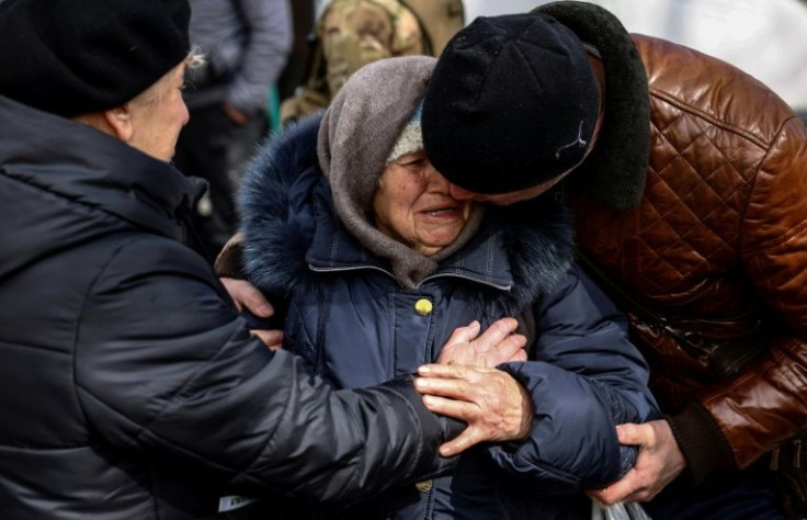 Molchanova's adult children comfort her after her after she arrives at an evacuation centre on the outskirts of Kyiv