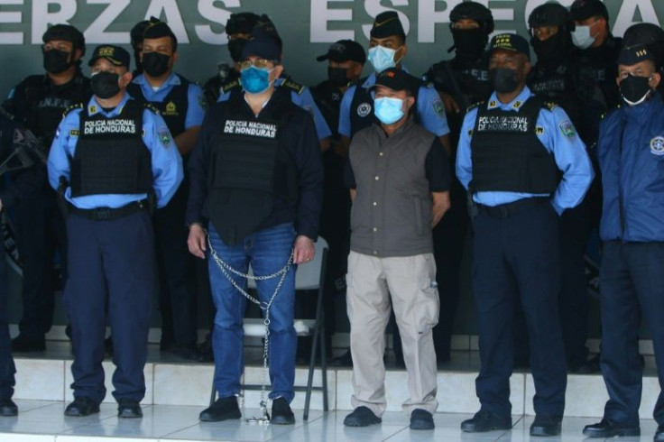 Former Honduras president Juan Orlando Hernandez (middle) was paraded in chains by police following his arrest on February 15, 2022 on suspicion of drug-trafficking