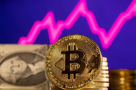A representations of cryptocurrency Bitcoin is seen in front of a stock graph and U.S. dollar in this illustration taken, January 24, 2022. 