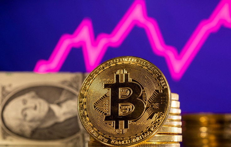 A representations of cryptocurrency Bitcoin is seen in front of a stock graph and U.S. dollar in this illustration taken, January 24, 2022. 