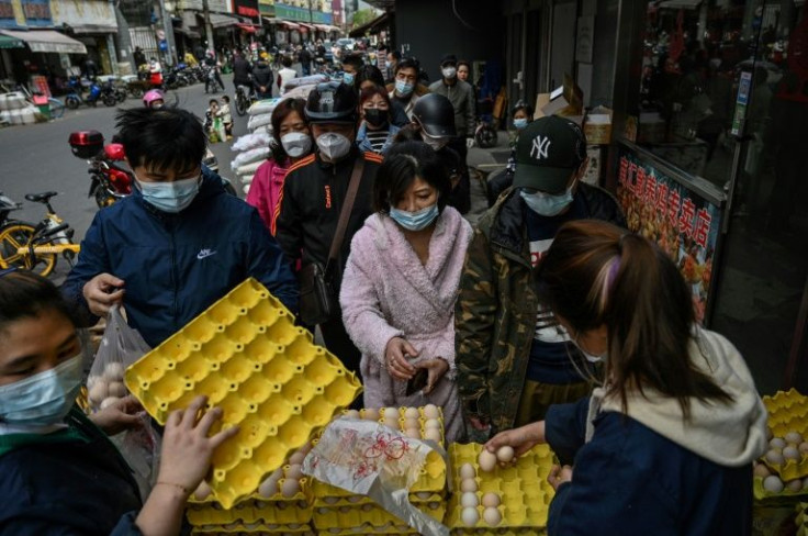People queue to buy eggs next to a market in Shanghai as residents stock up ahead of a lockdown