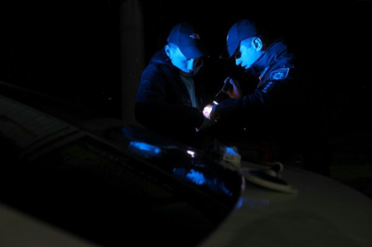 Officers check the documents of drivers caught out after hours
