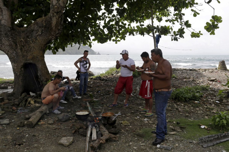 Cuban migrants eat next to a campfire in Puerto Obaldia town in Panama's Guana Yala Region September 16, 2015. Picture taken on September 16, 2015. 
