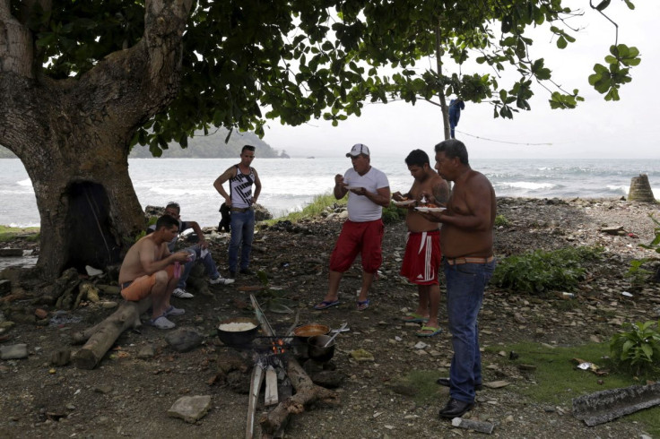 Cuban migrants eat next to a campfire in Puerto Obaldia town in Panama's Guana Yala Region September 16, 2015. Picture taken on September 16, 2015.