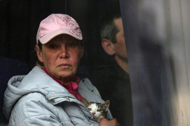 An evacuee holds a cat as she sits in a bus coming from the village of Rudnytske