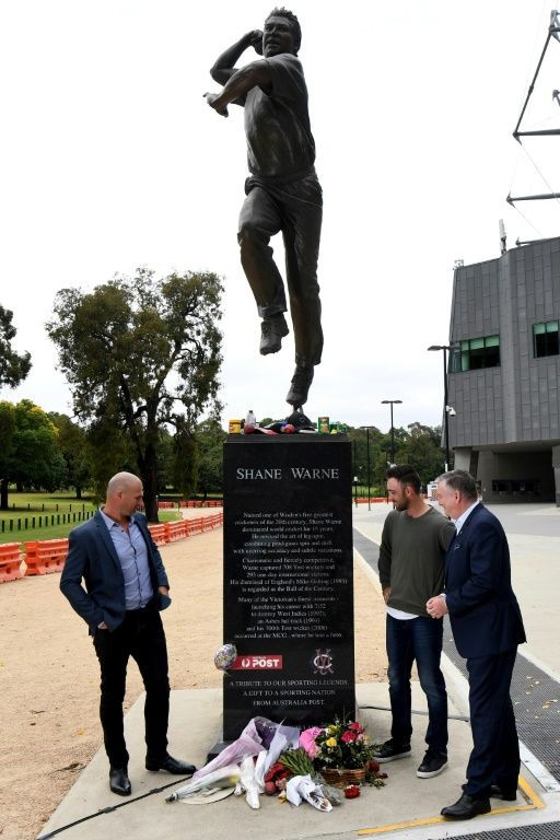 Australia cricketer Glenn Maxwell (second right), former Australian Rules footballer Aaron Hamill (left) and media personality Eddie McGuire pay their respects at Shane Warne's statue outside the Melbourne Cricket Ground