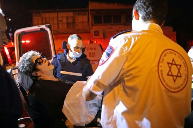 Israeli emergency personnel evacuate a wounded woman from the scene of the shooting