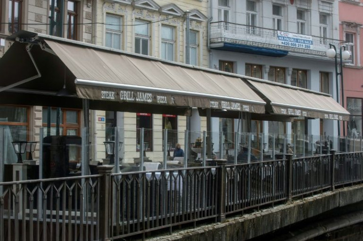 A "For Sale" sign hangs from the balcony of a house (R) behind a restaurant in Karlovy Vary, Czech Republic.