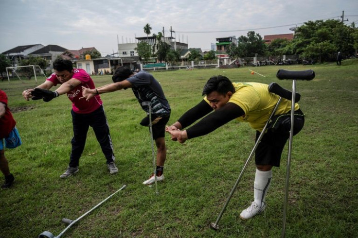 Syaiful Arifin (in yellow) warms up ahead of a training session