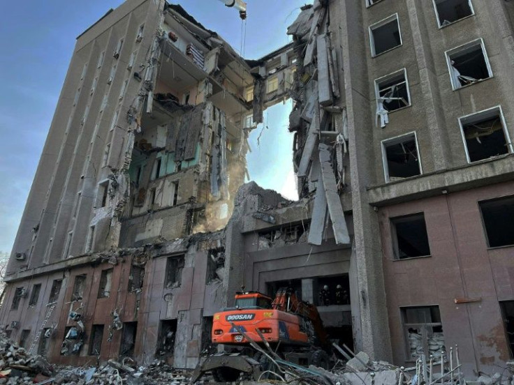 Ukraine rescuers dismantle the debris of a government building in the southern city of Mykolaiv, where 14 people were killed in a rocket strike
