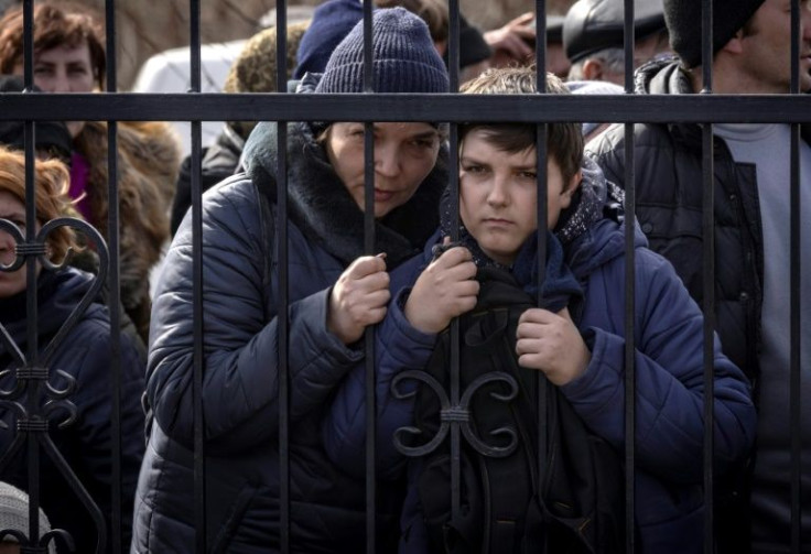 Residents wait for food outside a church in the northeastern city of Trostianets