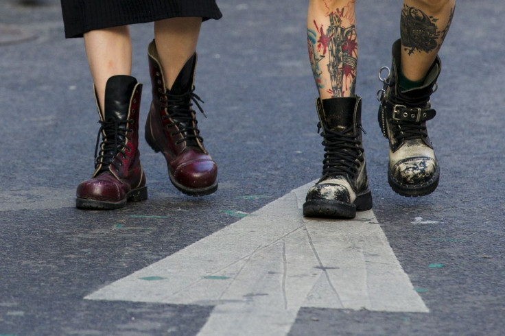 A tattooed man and a woman wear heavy boots as they walk in the trendy shopping district of Hongdae in Seoul, May 3, 2015.