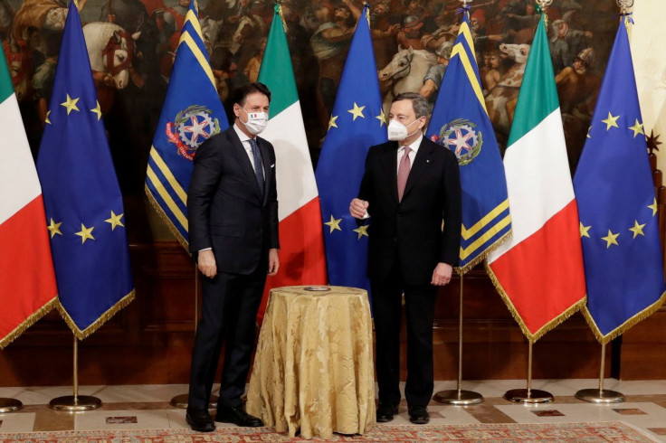 New Italian Prime Minister Mario Draghi holds the cabinet minister bell next to outgoing Premier Giuseppe Conte, during the handover ceremony at Chigi Palace Premier's office, in Rome, Italy February 13, 2021. Andrew Medichini/Pool via 