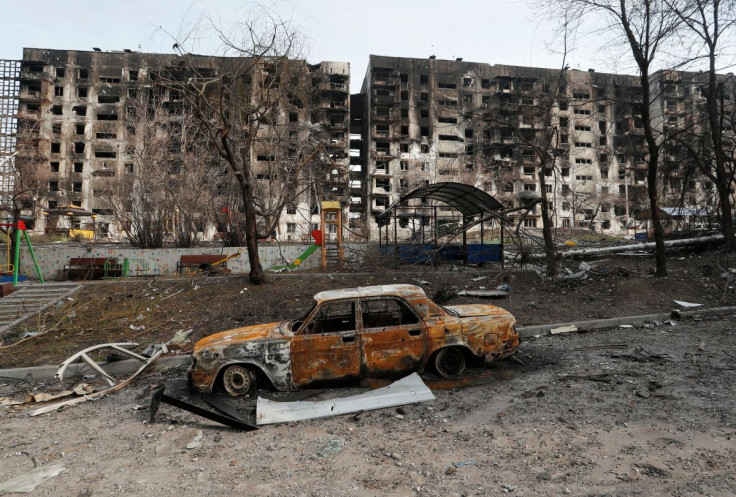 A charred car is seen in front of an apartment building destroyed during Ukraine-Russia conflict in the besieged southern port city of Mariupol, Ukraine March 30, 2022.