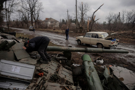 A local man looks into a Russian tank left behind after Ukrainian forces expelled Russian soldiers from the town of Trostyanets which they had occupied at the beginning of its war with Ukraine, March 30, 2022.  