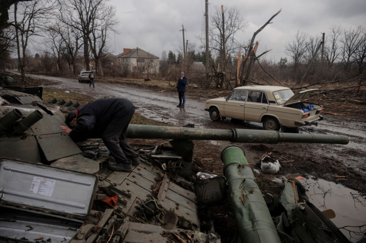 A local man looks into a Russian tank left behind after Ukrainian forces expelled Russian soldiers from the town of Trostyanets which they had occupied at the beginning of its war with Ukraine, March 30, 2022.  