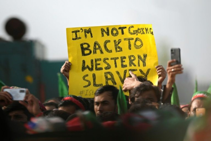 A supporter of the ruling Pakistan Tehreek-e-Insaf party holds a placard during a rally by Pakistan's Prime Minister Imran Khan in Islamabad on March 27